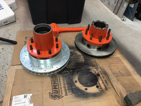 1992 Jeep Wrangler - A pair of new brake rotors and hubs are laid out on a cardboard box, ready for installation.