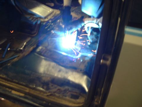 1989 Ford Bronco - A person is welding inside the interior of a vehicle, with bright sparks illuminating the scene.