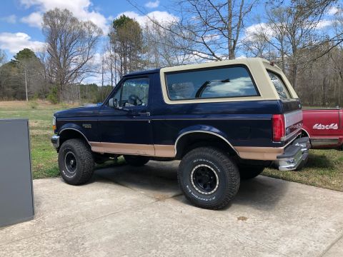 1995 Ford Bronco - This 1995 Ford Bronco is seen from the side, its distinctive two-tone paint and removable top.