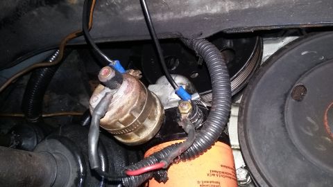 Engine oil filter with wiring connected to a component, and pulleys visible