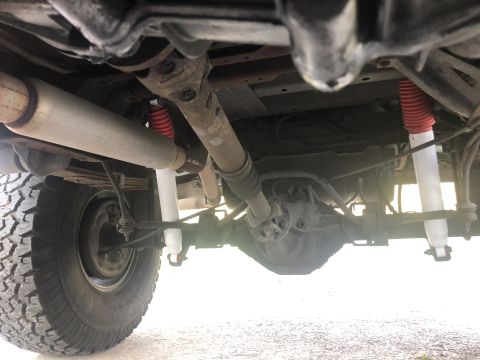 1995 Ford Bronco - Undercarriage view of a truck, focusing on the rear axle and suspension.
