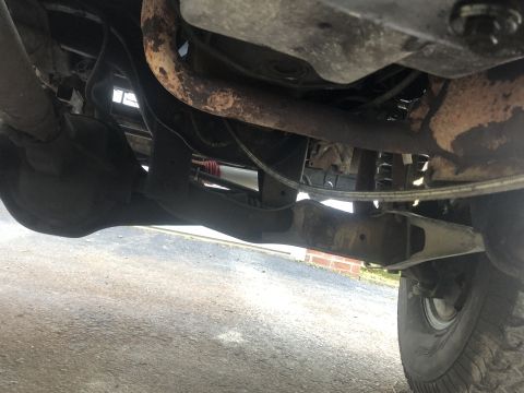 1995 Ford Bronco - A close-up view of the vehicle's undercarriage reveals its suspension components and exhaust system.