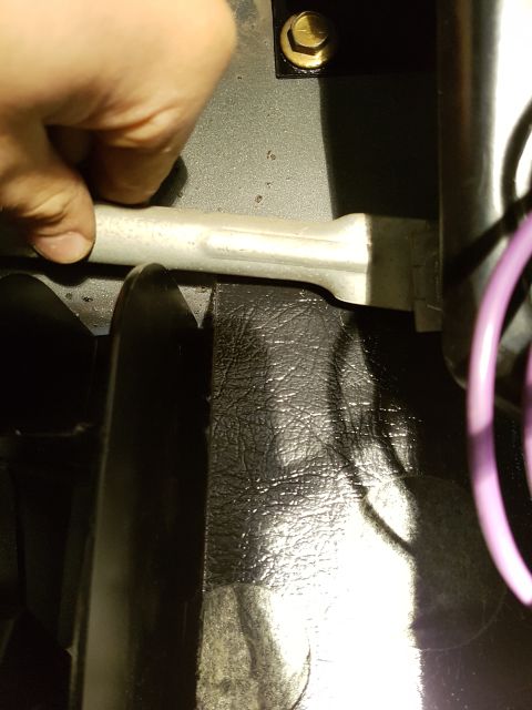 1978 Ford Bronco - A person's hand is shown holding a metal component that appears to be part of a vehicle's exhaust system. The component is silver and has a…