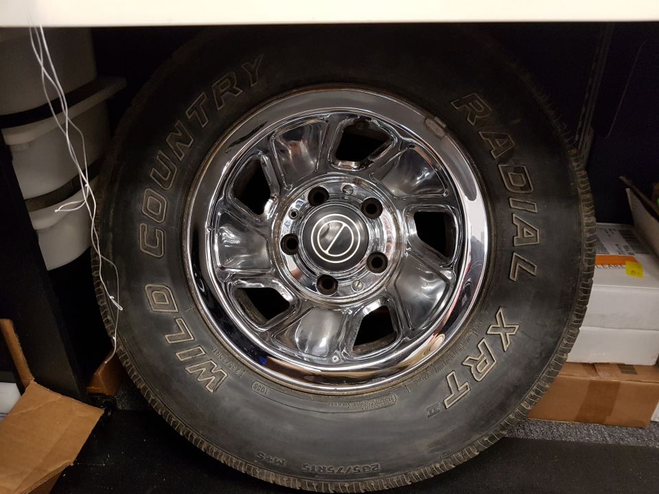Close-up of a tire and chrome rim with "Wild Country Radial XRT" text.