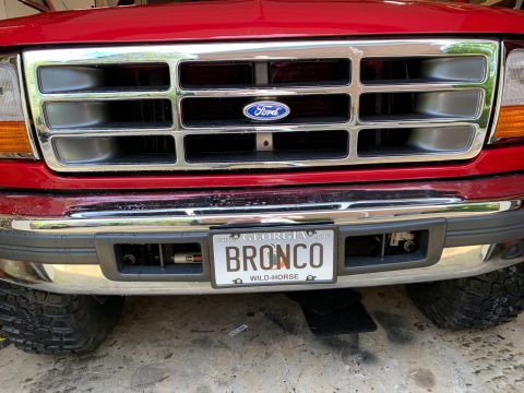 1994 Ford Bronco - The front grille and bumper of a red Ford Bronco are visible. A license plate reads "BRONCO" and "GEORGIA".