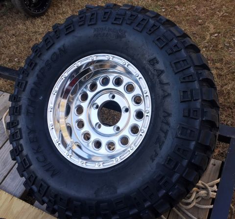 1994 Ford Bronco - A close-up view of a Mickey Thompson Baja MTZ P3 tire mounted on a polished aluminum wheel. The tire is large and aggressive, designed for…