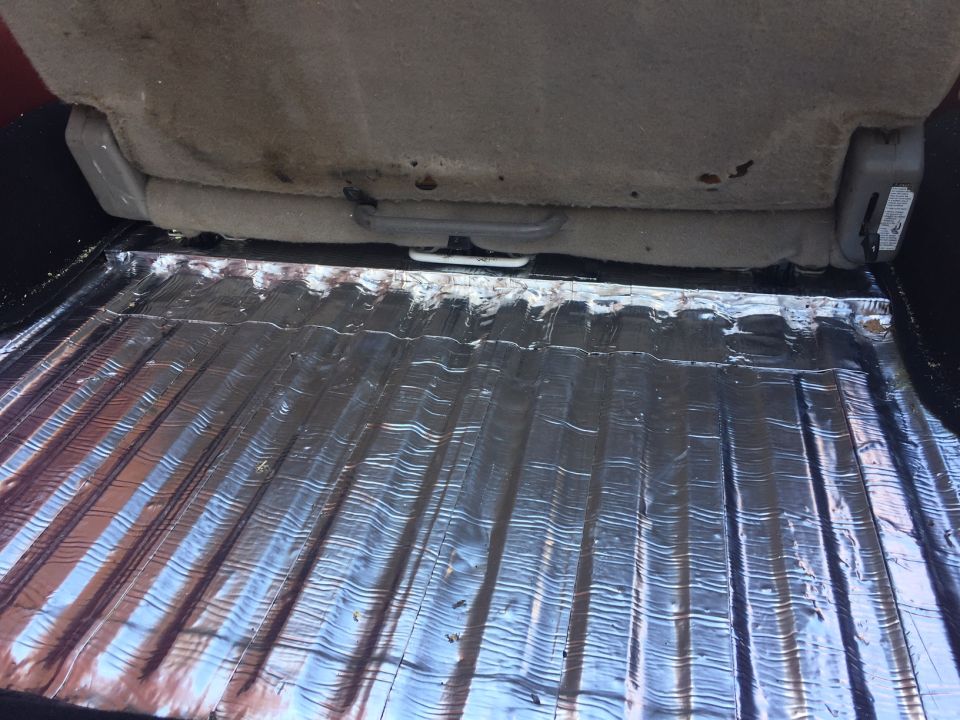 Reflective sound deadening material covering the floor of a vehicle's cargo area.