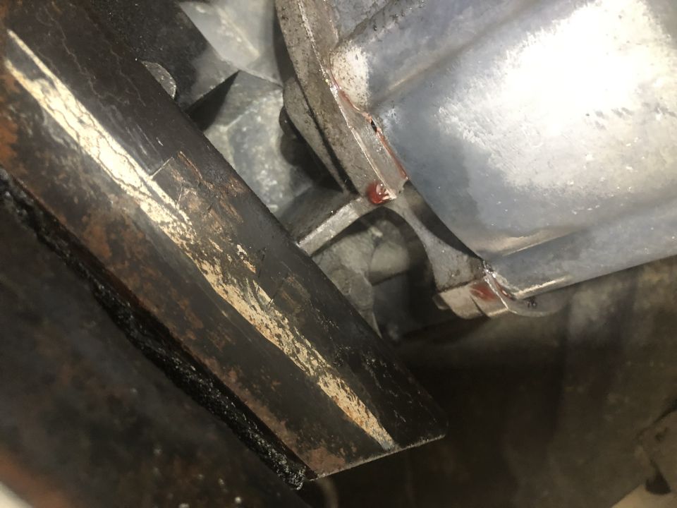 Close-up of metal bracket with residue and housing with red sealant