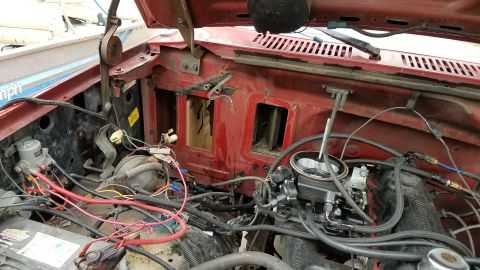 1985 Ford Bronco - The interior of a vehicle, with a focus on the red upholstery and surrounding parts.