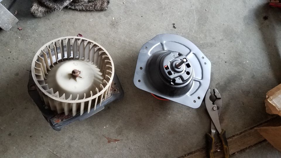 blower motor and squirrel cage assembly on concrete floor with pliers nearby