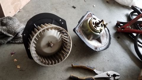 1985 Ford Bronco - Disassembled blower motor and fan assembly for a vehicle's air conditioning system.