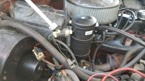 1985 Ford Bronco - This is a close-up view of the engine bay of a 1985 Ford Bronco, focusing on the air conditioning system's receiver-drier and related hoses…