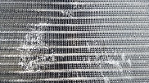 1985 Ford Bronco - This is a close-up, straight-on shot of a damaged condenser coil, likely from an air conditioning unit. The fins are bent and distorted in…