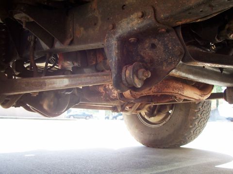 1979 Ford Bronco - The underside of a heavily rusted 1978 Ford Bronco reveals its suspension components and differential.