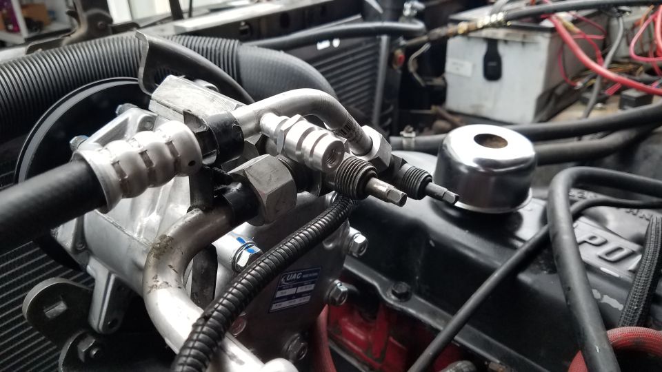 Close-up of AC compressor and lines in engine bay