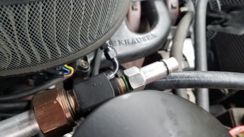 1985 Ford Bronco - Close-up view of a modified engine bay showing an air filter housing, exhaust manifold with "EDELBROCK" visible, and various hoses and fitt…