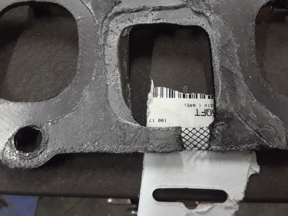 Exhaust manifold gasket with torn label