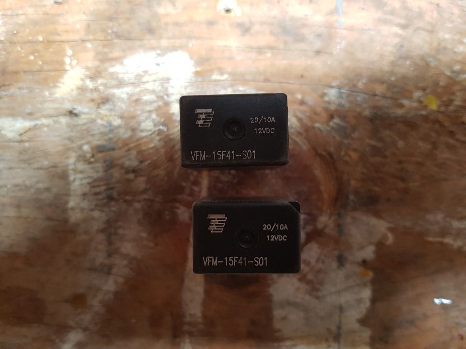 Two identical black automotive relays with "VFM-15F41-S01" and "20/10A 12VDC" markings.