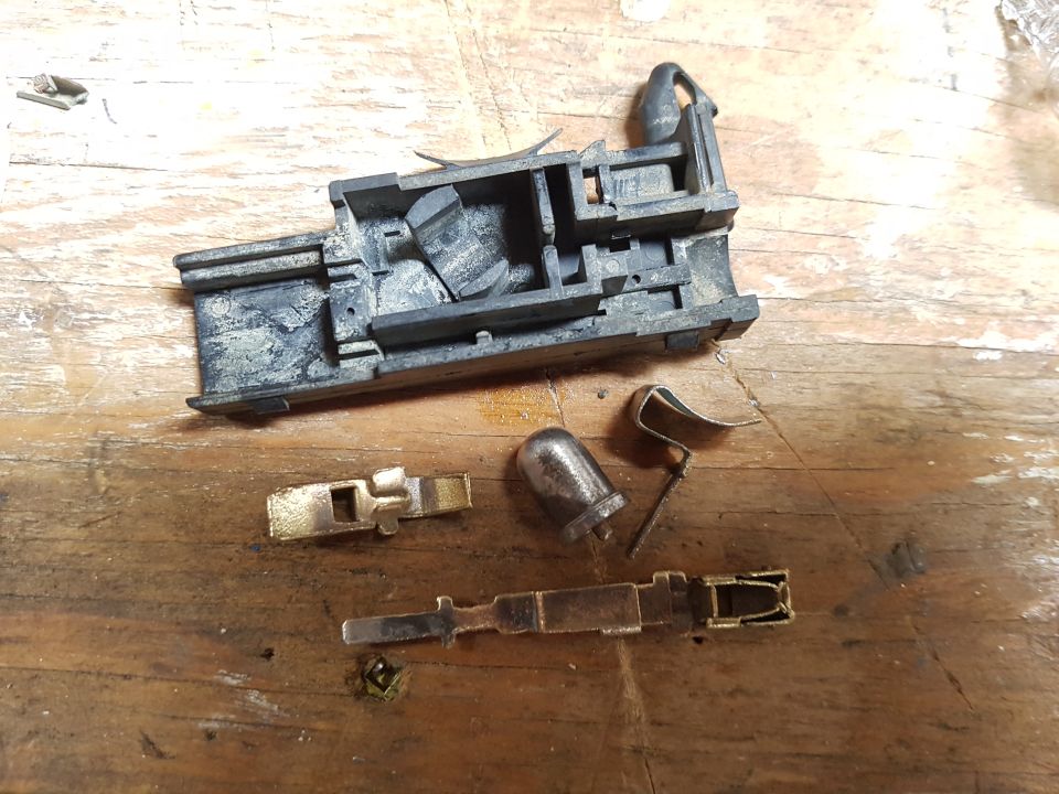 Disassembled electrical connector parts on a wooden surface.