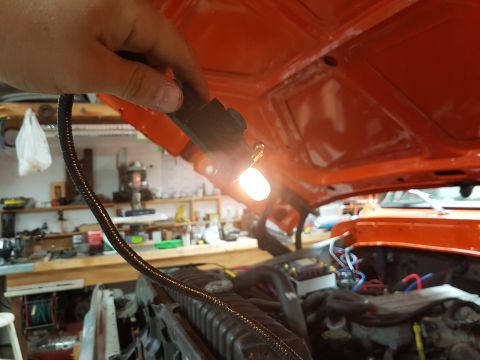 1978 Ford Bronco - Working on the engine bay with a test light, checking electrical components.