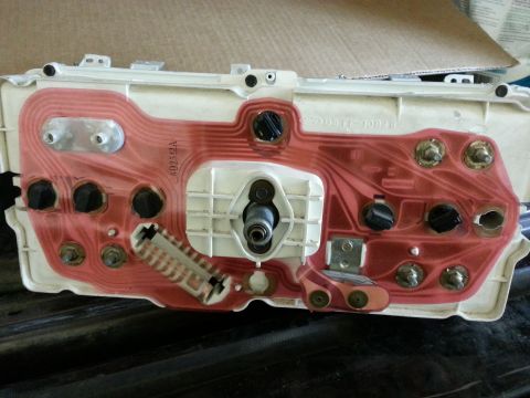 1978 Ford Bronco - The rear of a vehicle's instrument cluster wiring harness, showing the red circuit traces and various electrical connectors.