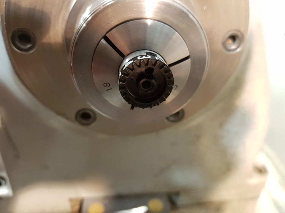 Close-up of a metal part with gear teeth and the number 18 visible