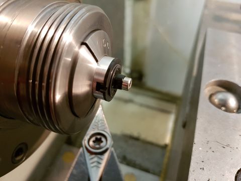 1978 Ford Bronco - A metal part is precisely shaped using a lathe and cutting tool in a workshop setting.