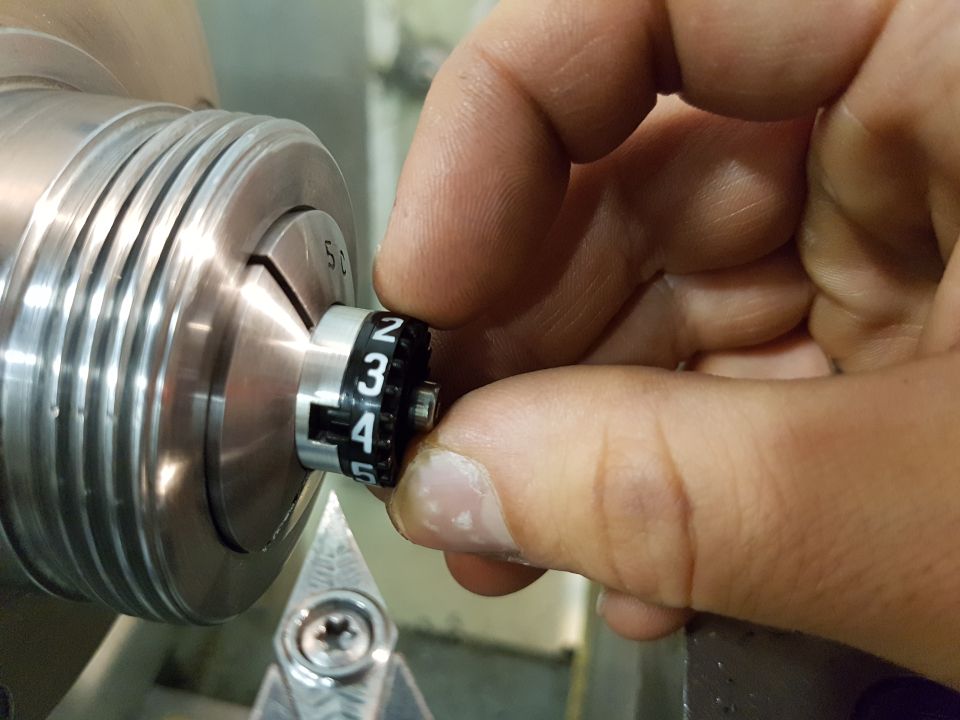 Dial with numbers 2, 3, 4, 5 being adjusted by a hand