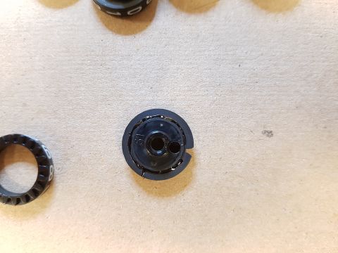 1978 Ford Bronco - Several black knobs with white numbers are laid out on a textured surface.