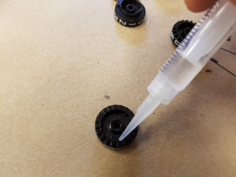 1978 Ford Bronco - A close-up shows a syringe dispensing glue onto a small component, with other numbered parts nearby.
