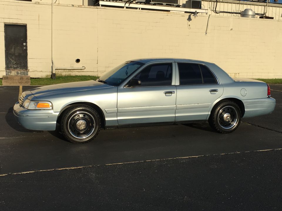 2006 Ford Crown Victoria sedan, side view. Light blue paint, black steel wheels