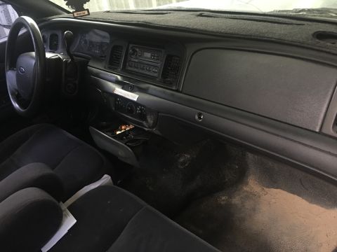 2006 Ford Crown Victoria - The interior of a car, showing the dashboard, steering wheel, and front seats.