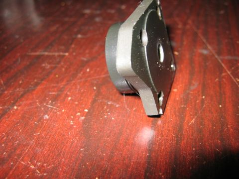 1993 Ford F-150 - A metal component with a circular protrusion is shown against a wooden background.