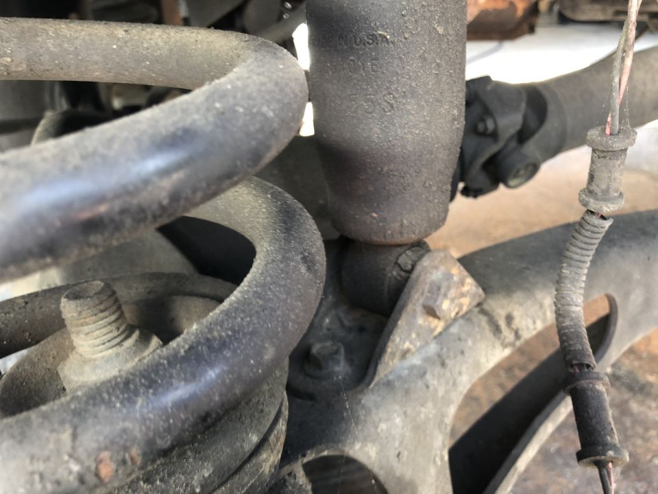 Close-up of rear suspension components, including a coil spring and shock absorber