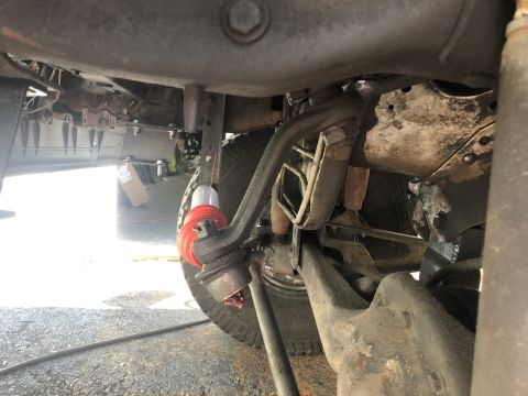1995 Ford Bronco - Close-up of the suspension system, highlighting the ball joint and its red bushings.