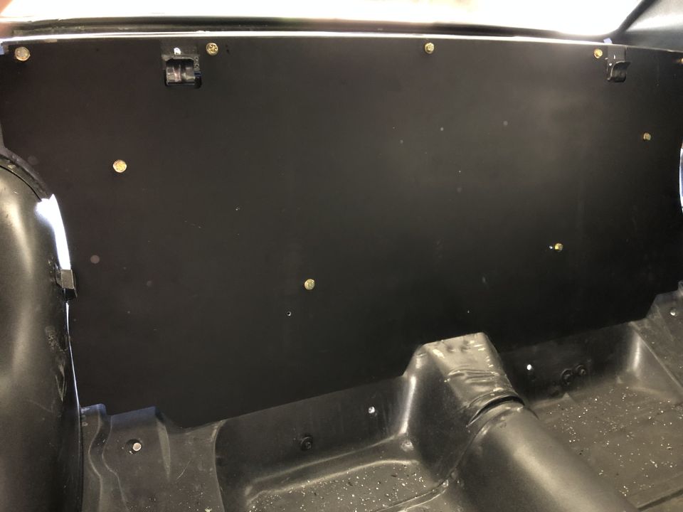 Black trunk or rear interior panel with fasteners inside a vehicle body