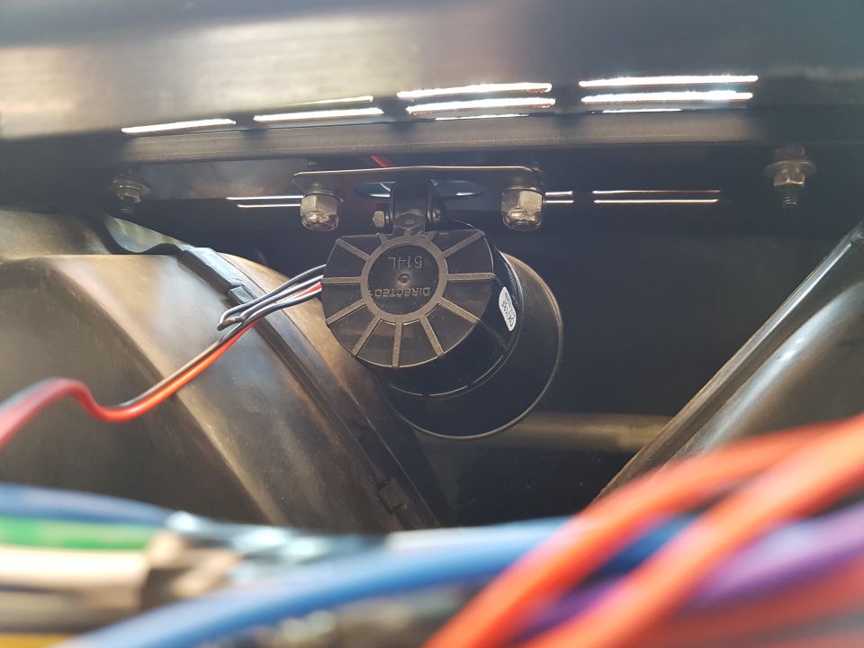 Black Directed 514L siren with wires mounted above dark plastic.