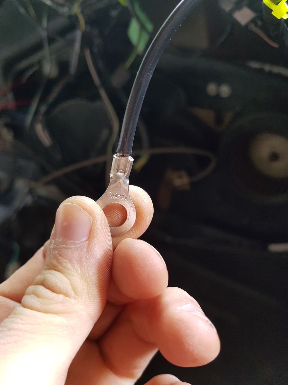 Wire with ring terminal labeled R2-10, with vehicle wiring in background.