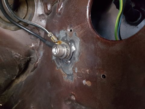 1978 Ford Bronco - A close-up view shows a metal panel with a silver bolt and a ground lug attached. Wires are connected to the lug, and there is evidence of…