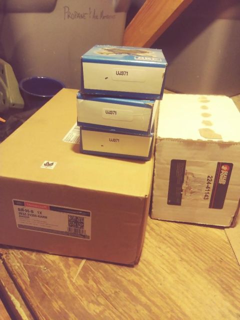1996 Ford Bronco - Three small boxes labeled "UJ371" are stacked on top of a larger cardboard box. The larger box has a Motorcraft label with part information.
