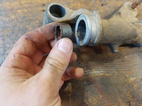 1978 Ford Bronco - A hand holds a worn, rusted metal bushing against a similar metal component that appears to be part of a vehicle's brake system or similar…