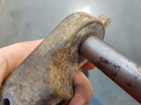 1978 Ford Bronco - A close-up view shows a rusty metal part with a rod inserted into it. The part appears to be a component from a vehicle's suspension or ste…