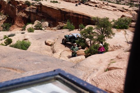 1995 Ford Bronco - A green off-road buggy is parked on a rocky, desert landscape. Two people are standing near the buggy, and several other off-road vehicles…