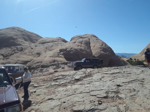 1985 Ford Bronco - A vehicle sits in a barren landscape under a clear blue sky.