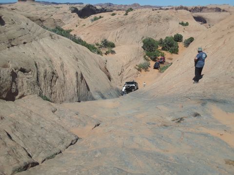 1985 Ford Bronco - A person stands in a vast desert landscape under a clear sky.