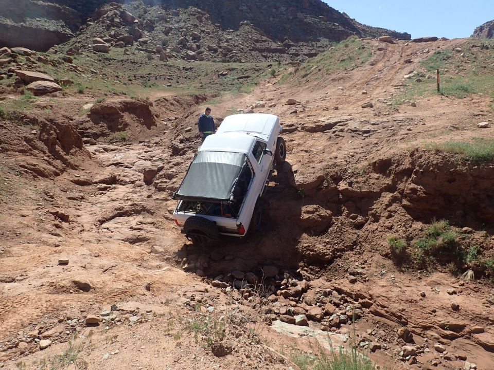 White 1995 Ford Bronco on a steep, rocky off-road trail.