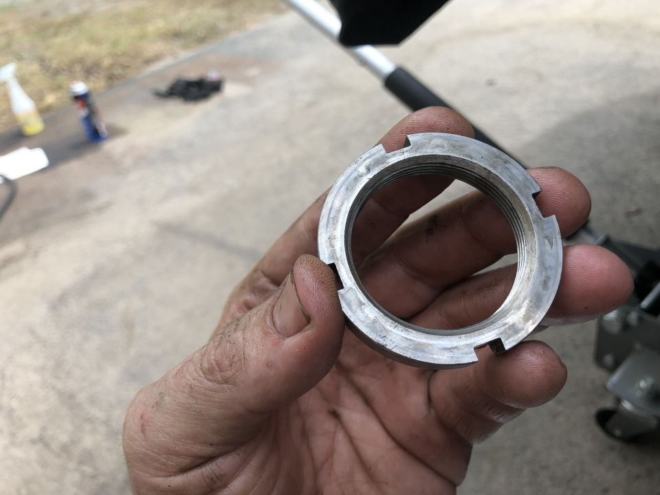 Close-up of a metal castle nut held in a hand.
