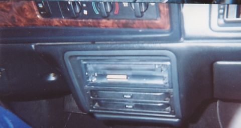 1991 Ford Taurus - The interior of a car shows a dashboard with climate controls and a CD changer unit.