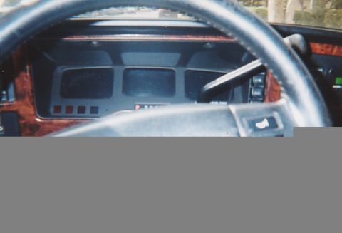 1991 Ford Taurus - Interior view of a car's dashboard, wood grain trim and a cluster of rectangular gauges.