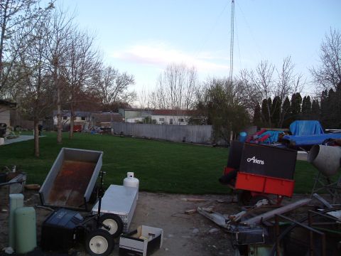 1979 Ford Bronco - A backyard scene with various pieces of equipment and a tall tower against a partly cloudy sky.